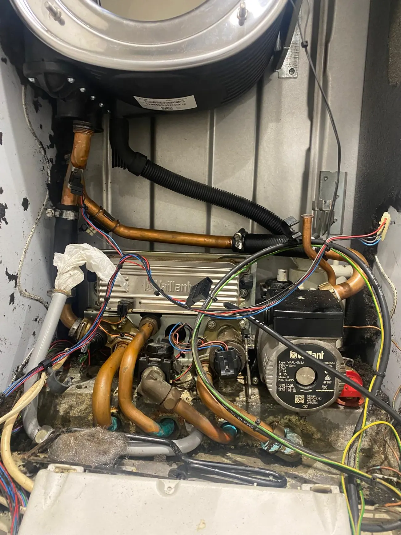 Inside a Vaillant combi boiler mid heat exchanger replacement, copper pipework and wiring exposed