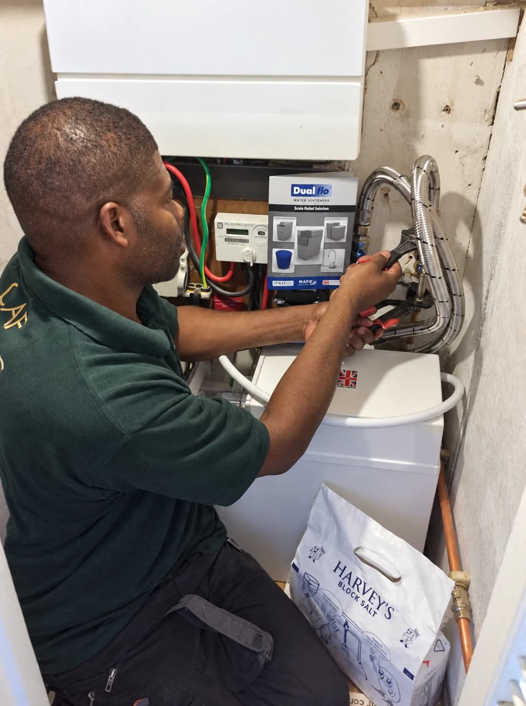 Carlton Fuller of CAF Heating connecting a Dualflo block-salt water softener in a cupboard